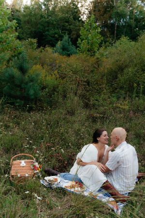 A romantic picnic setup in a wildflower meadow with a wicker basket and blanket.