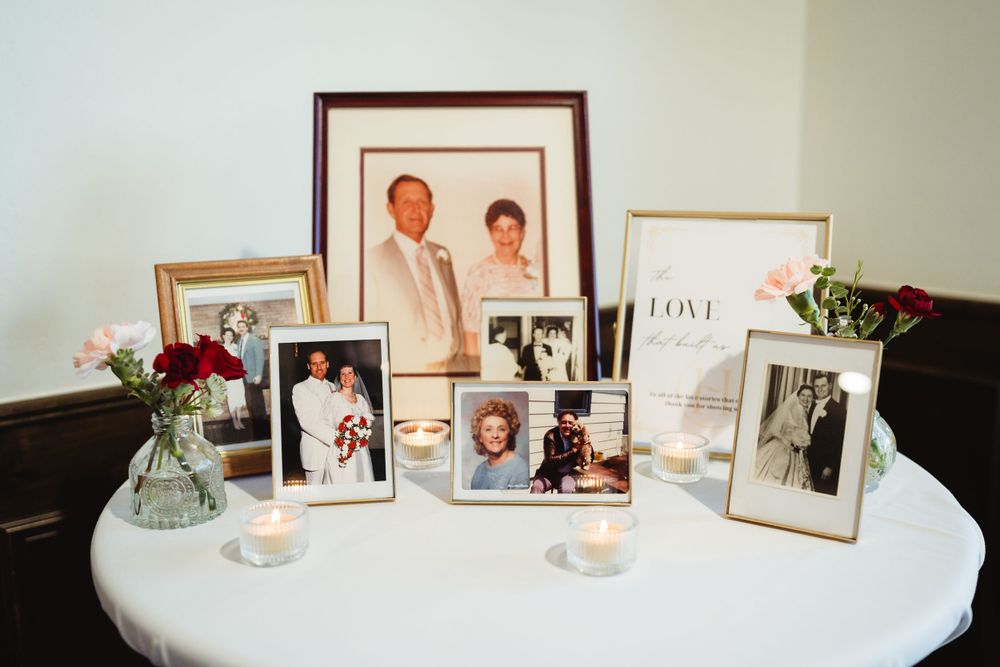 Vintage family photos and frames displayed on round white table with candlelight.