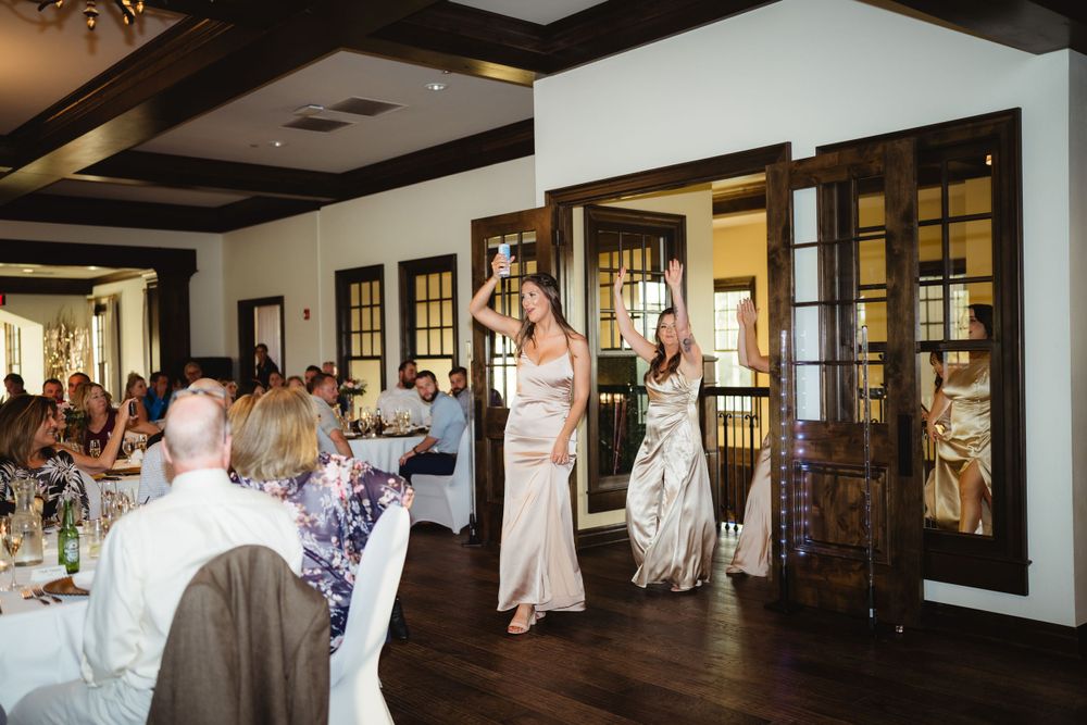 Wedding reception venue with dark wood floors and exposed beam ceiling.