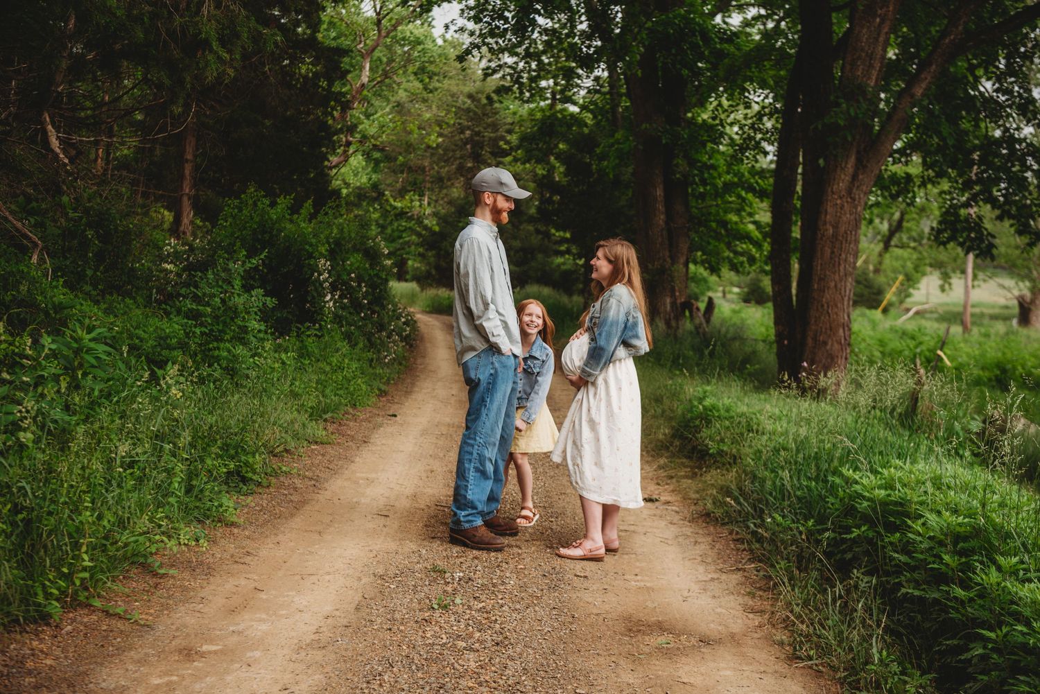 Couple walking together on a scenic dirt path surrounded by green foliage.