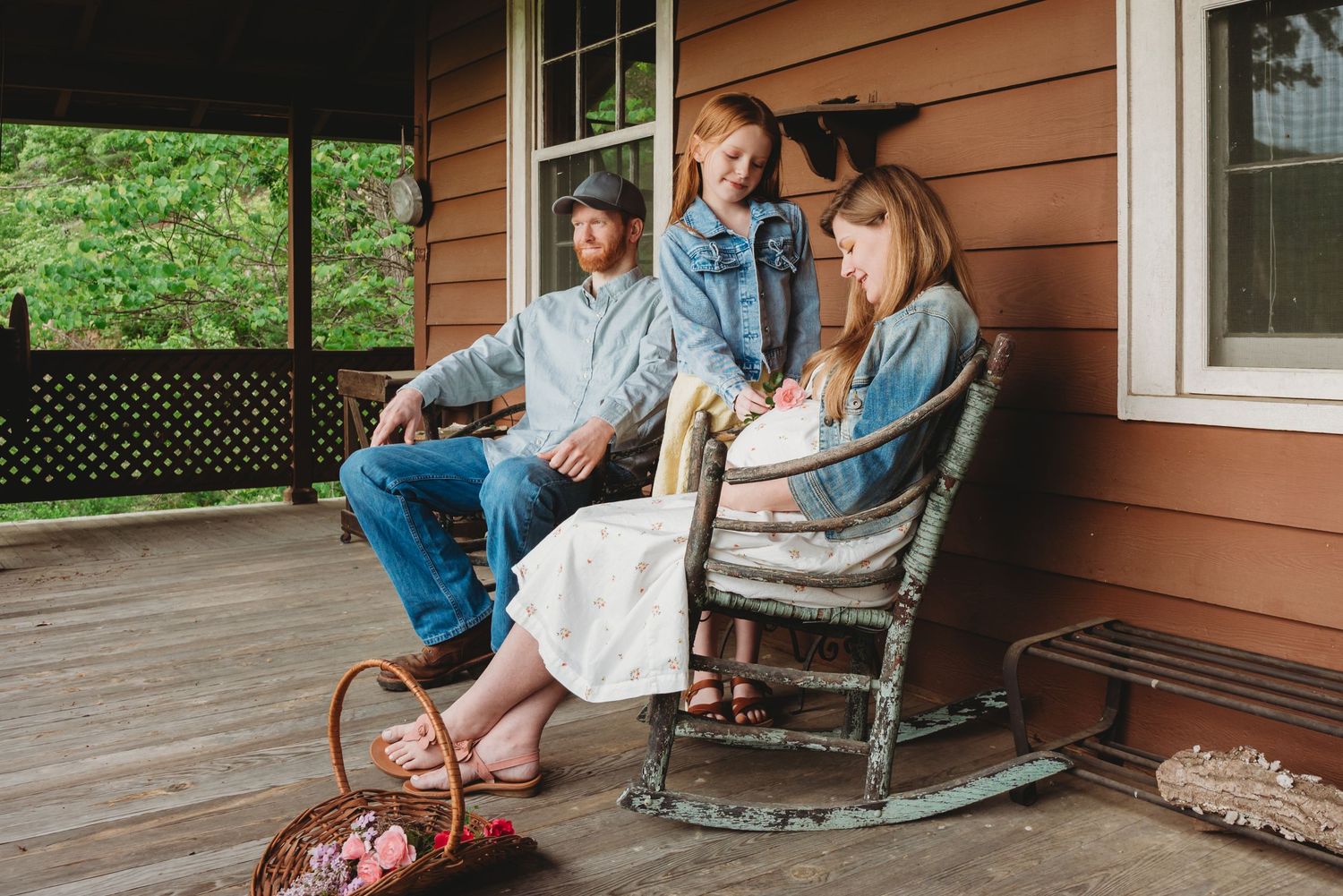 Family spending peaceful afternoon on rocking chairs at rustic cabin porch.