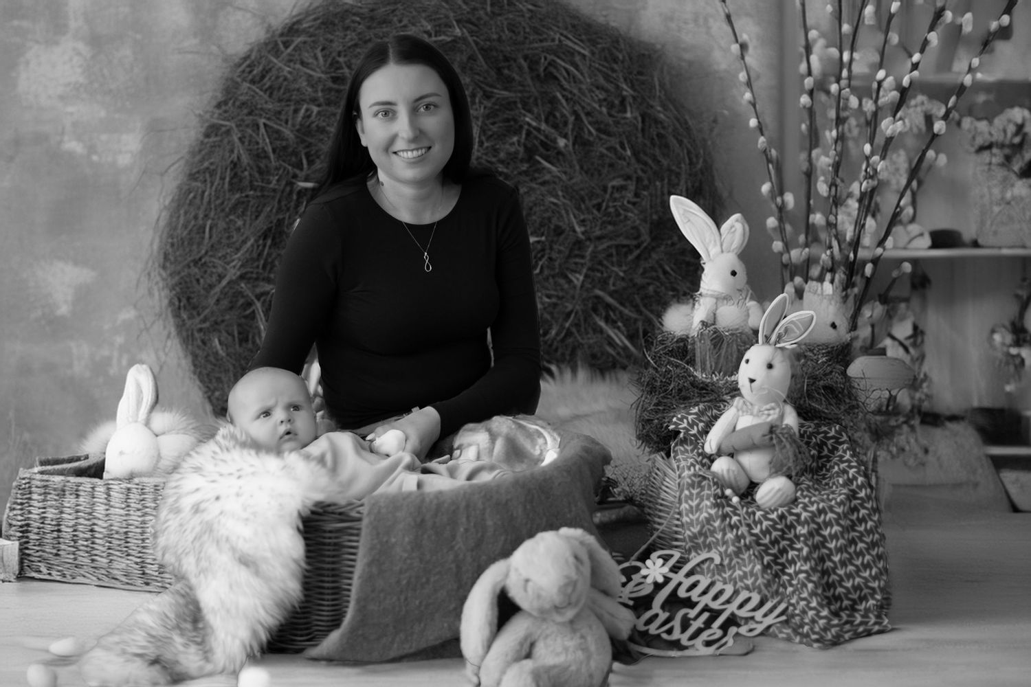 Black and white photo showing a spring themed display with stuffed bunnies, willow branches, and baskets arranged together.