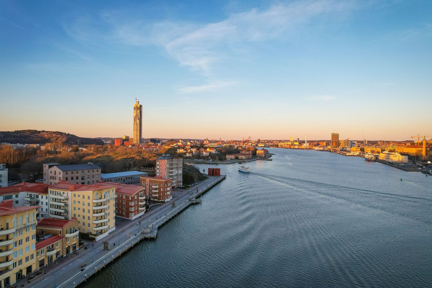Aerial view of Gothenburg city skyline with Lipstick Tower and waterfront buildings along river at sunset.