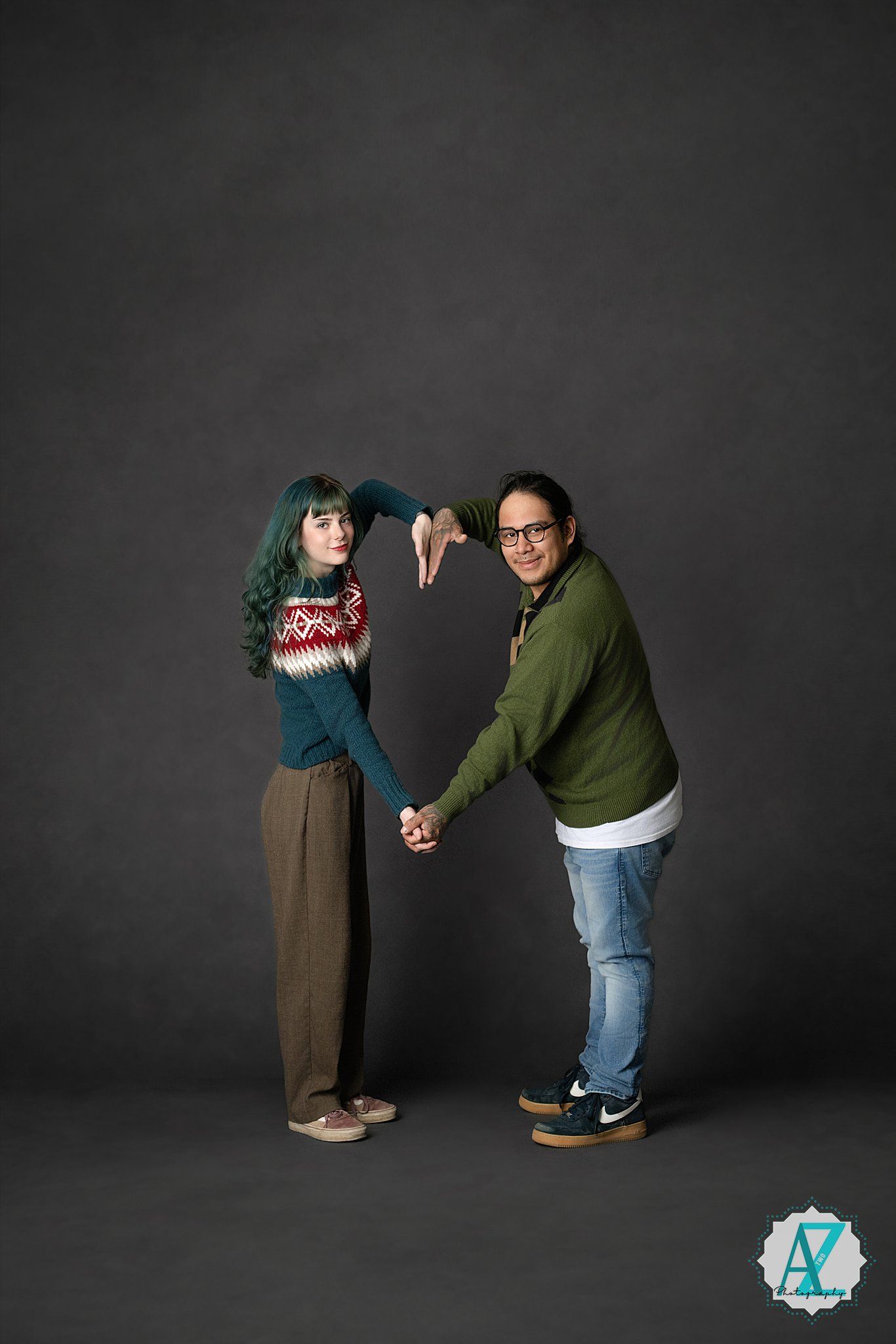 Two figures in casual attire perform playful poses against a dark background in a sequence of studio photographs.