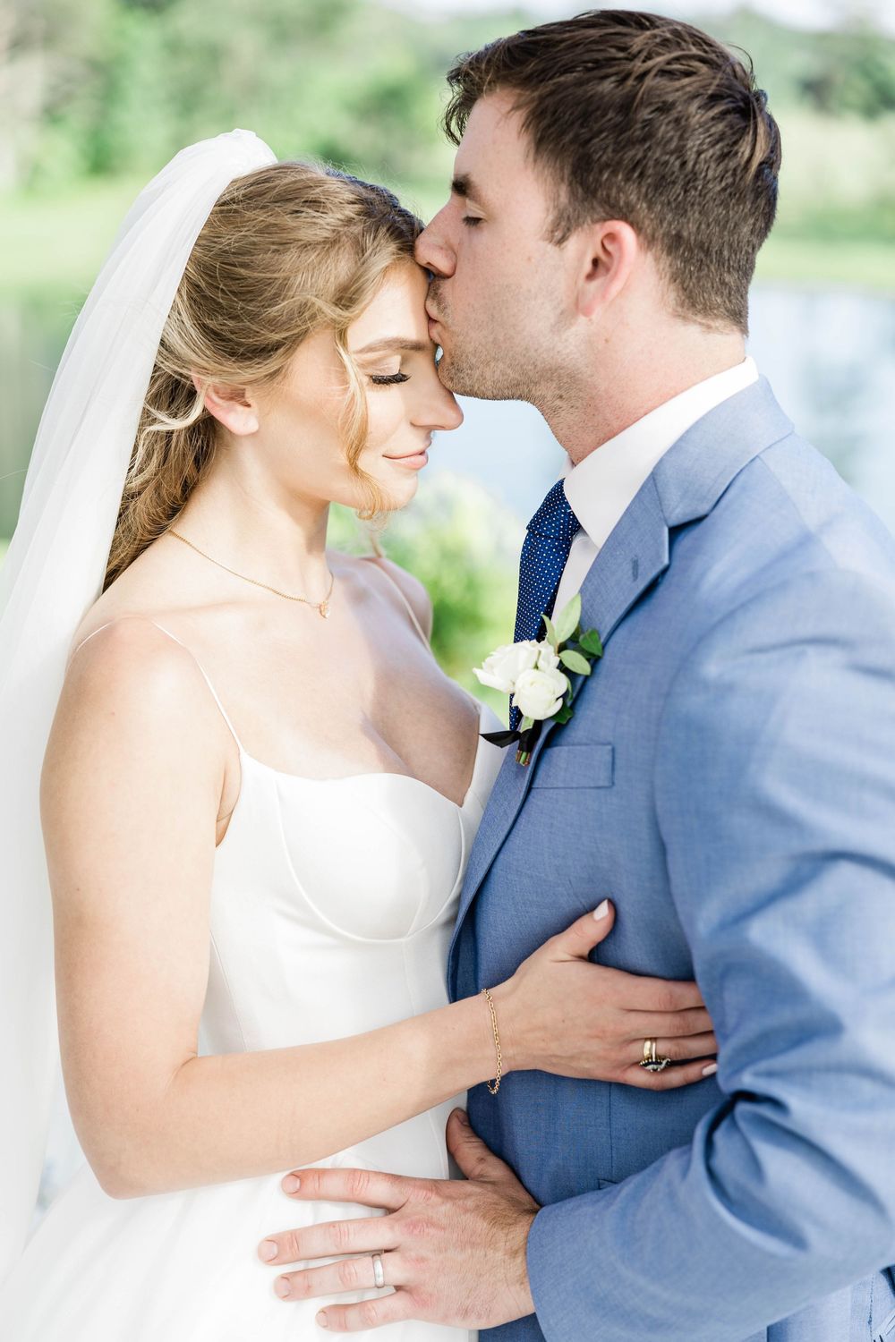 Intimate wedding moment captured as couple shares a tender kiss.