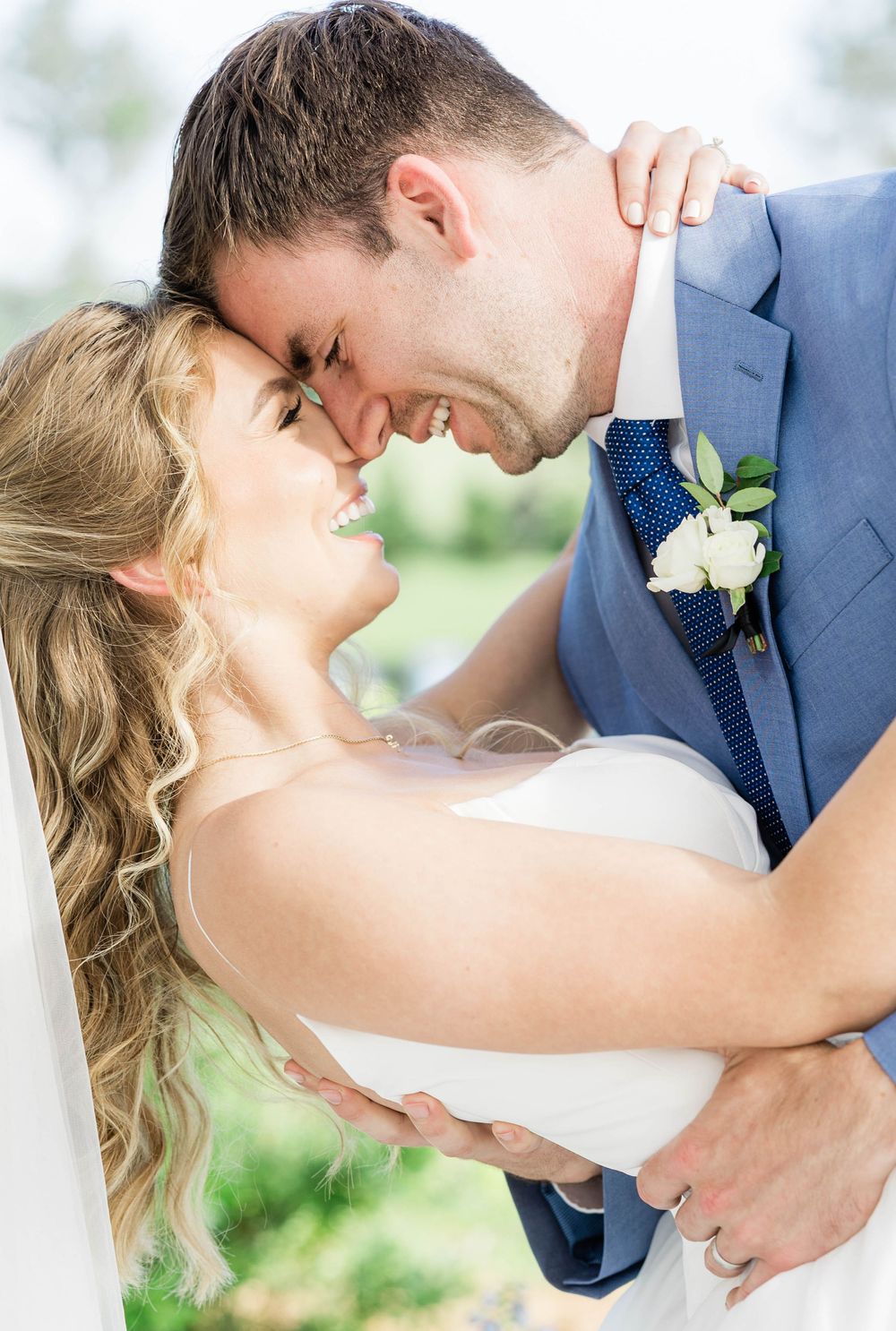 Candid laughing moment between bride and groom during wedding portraits.