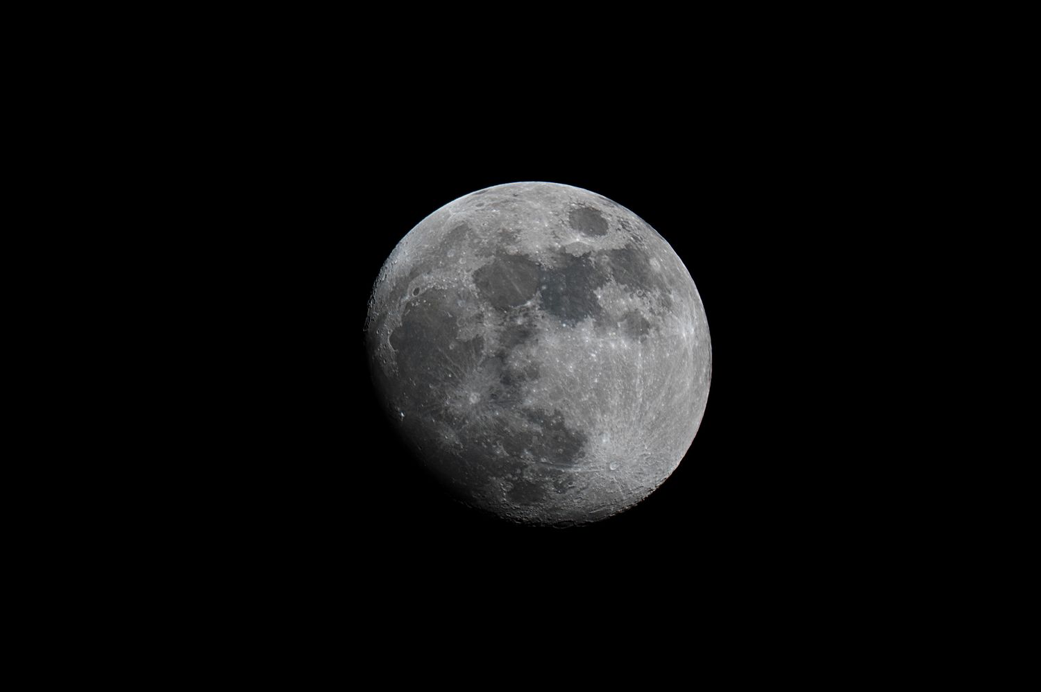 A detailed grayscale photograph of a waxing gibbous moon showing visible craters and surface features against a dark sky.