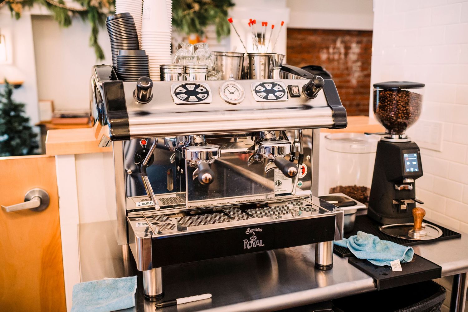 Professional coffee station setup with a commercial espresso machine and grinder on a black countertop.