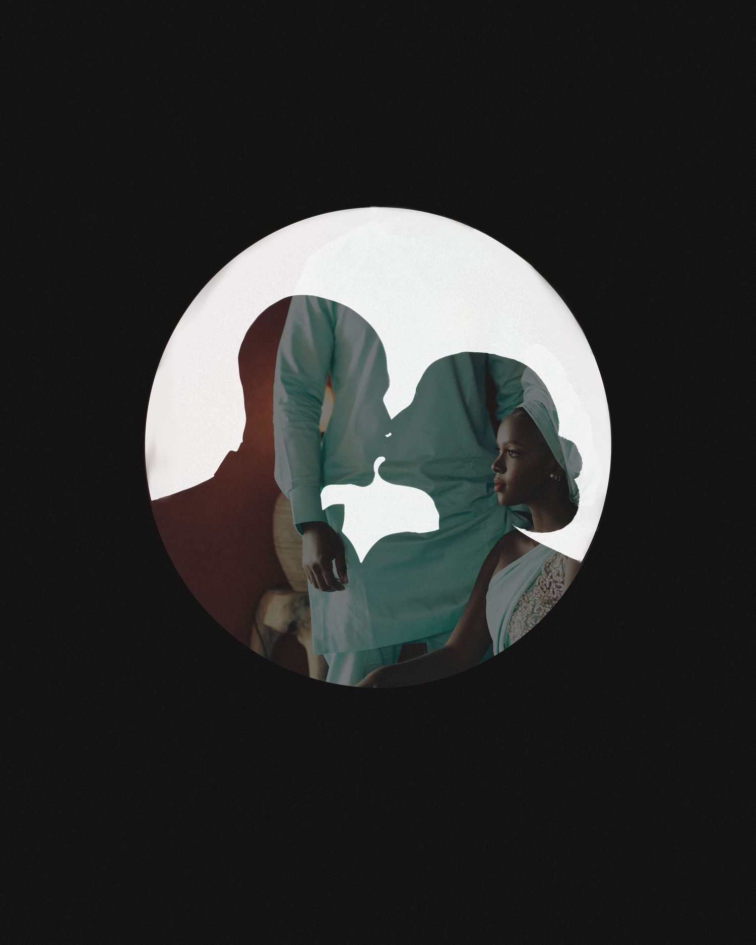 A black and white silhouette portrait in a circular frame shows a romantic side profile of a couple about to kiss.