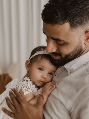 A tender moment between parent and child in a series of intimate black and white photographs.