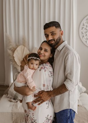 A loving father in white shirt shares sweet moments with child in light-filled room with white curtains.
