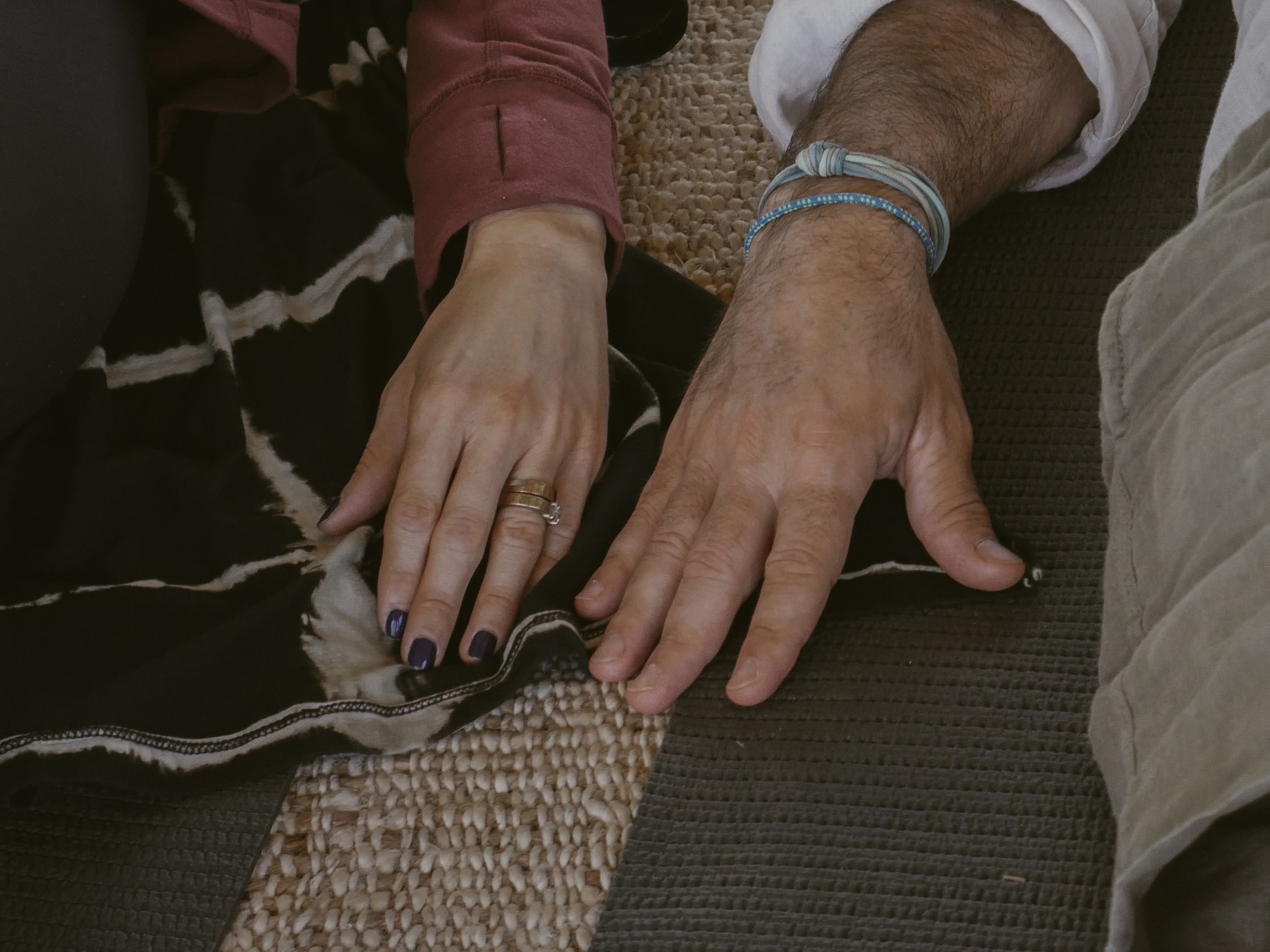 Person receiving a therapeutic neck massage on a woven mat.