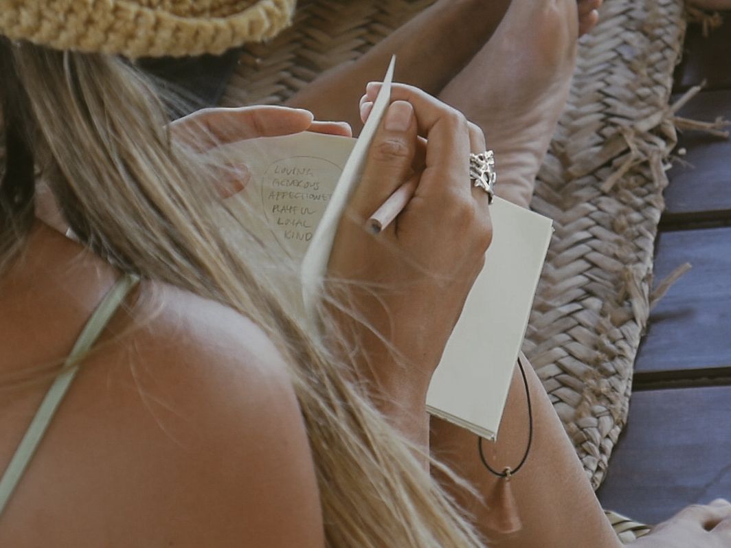 Close-up shot of hands holding a white price tag or label against woven texture.