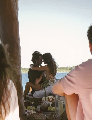 Intimate gathering of friends on wooden deck with ocean views.