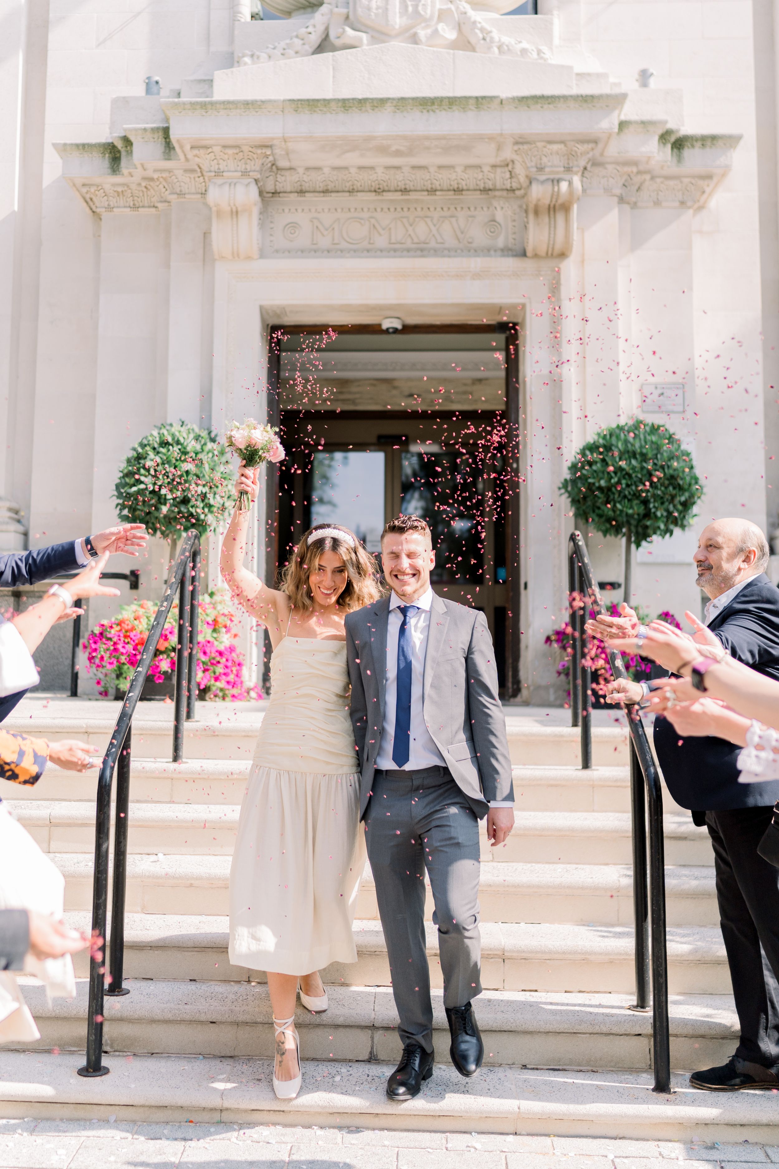Bride and groom smiling with joy during a confetti throw just after their ceremony at Islington Town Hall elopement in Central London.