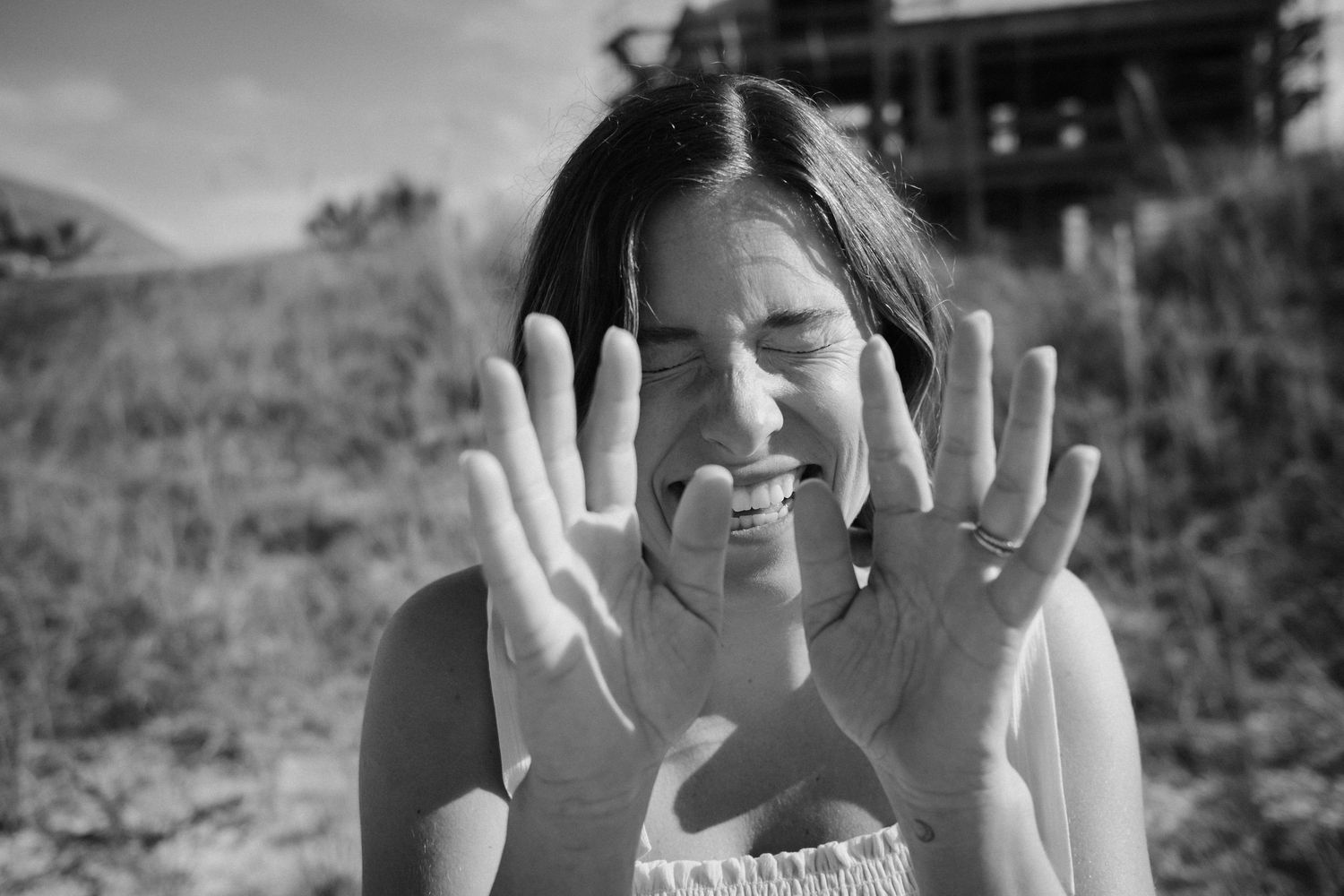 Playful hands raised against a blurred outdoor background.
