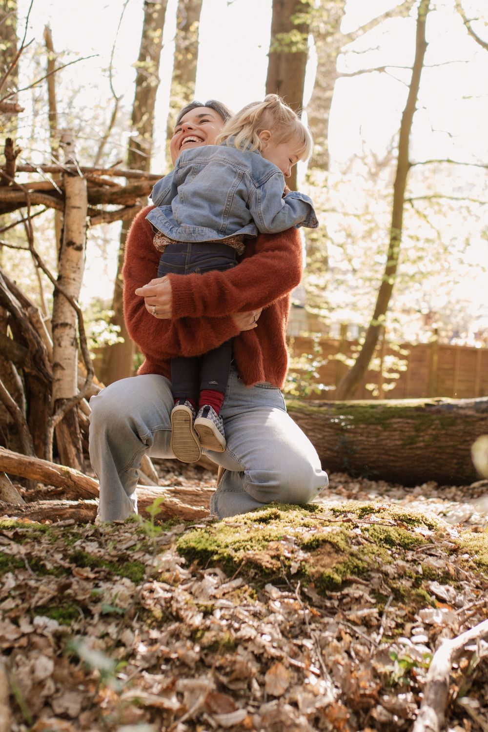 Playful interaction on fallen leaves in a sunlit forest setting.