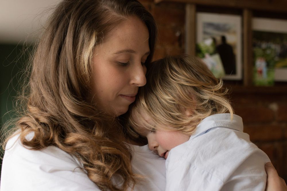 Intimate family moment captured in warm indoor lighting showing affection and connection.