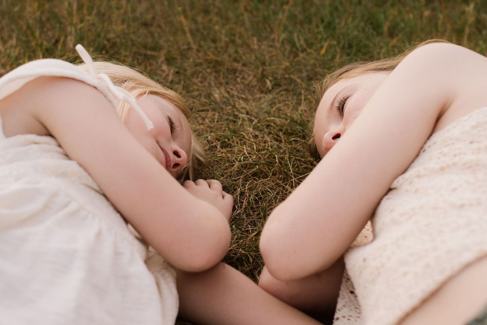 Artistic close-up shots of someone lying peacefully in lace dress on grass.