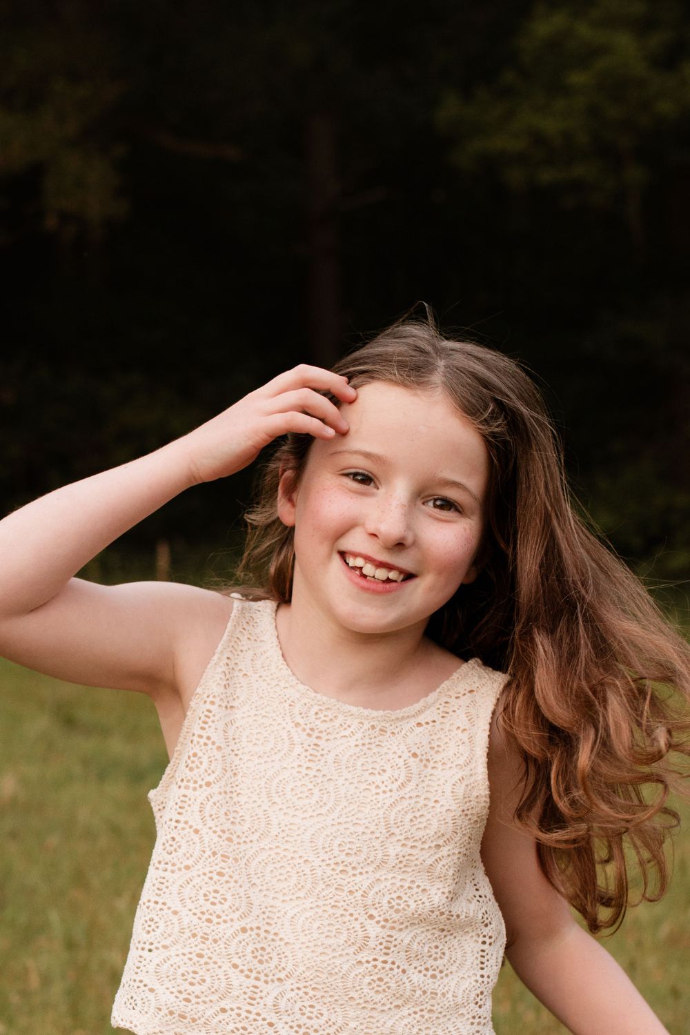 Young person in lace dress posing playfully outdoors in a sequence of expressions.