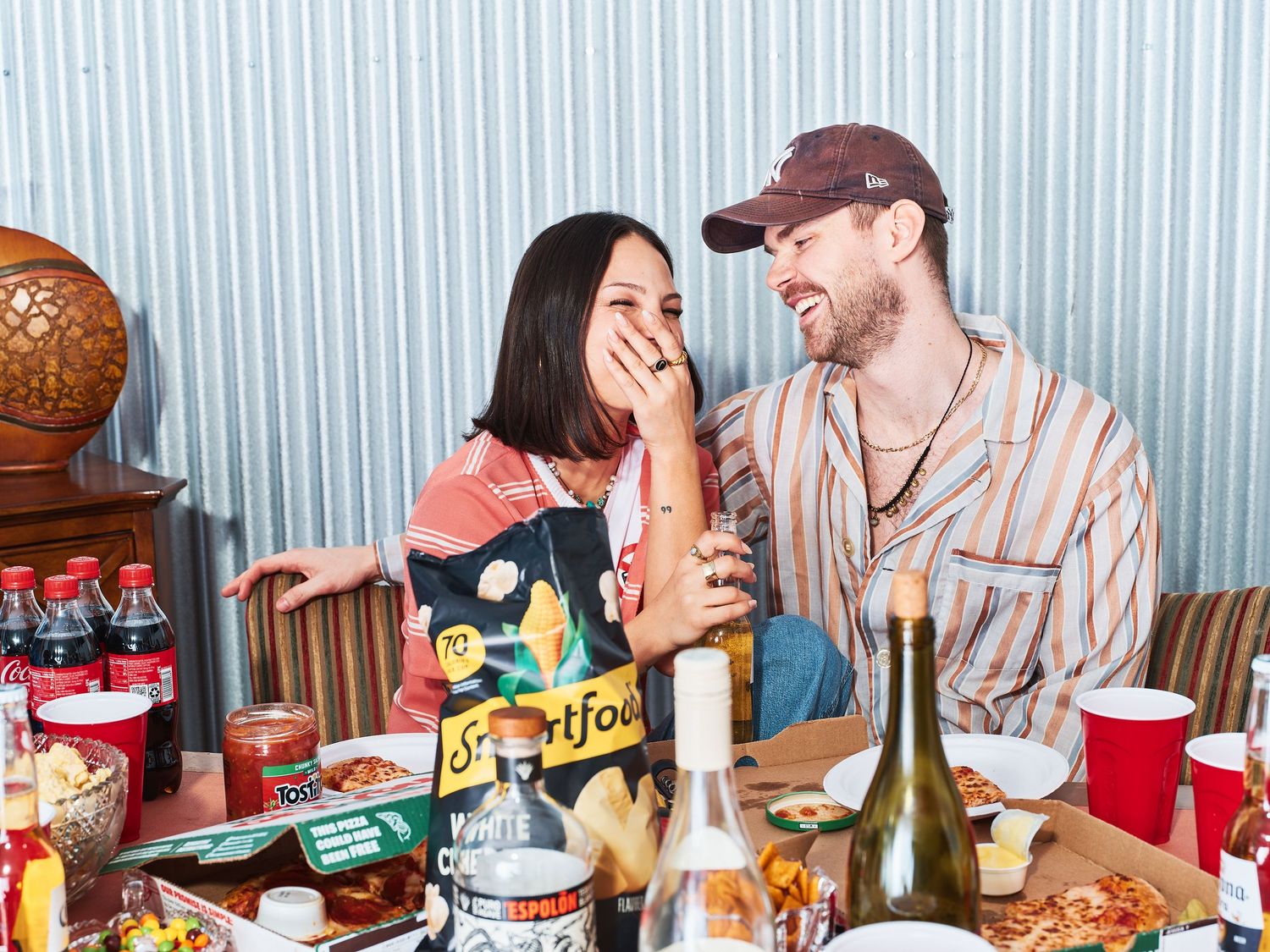 Casual dining scene with snacks and beverages on wooden table.