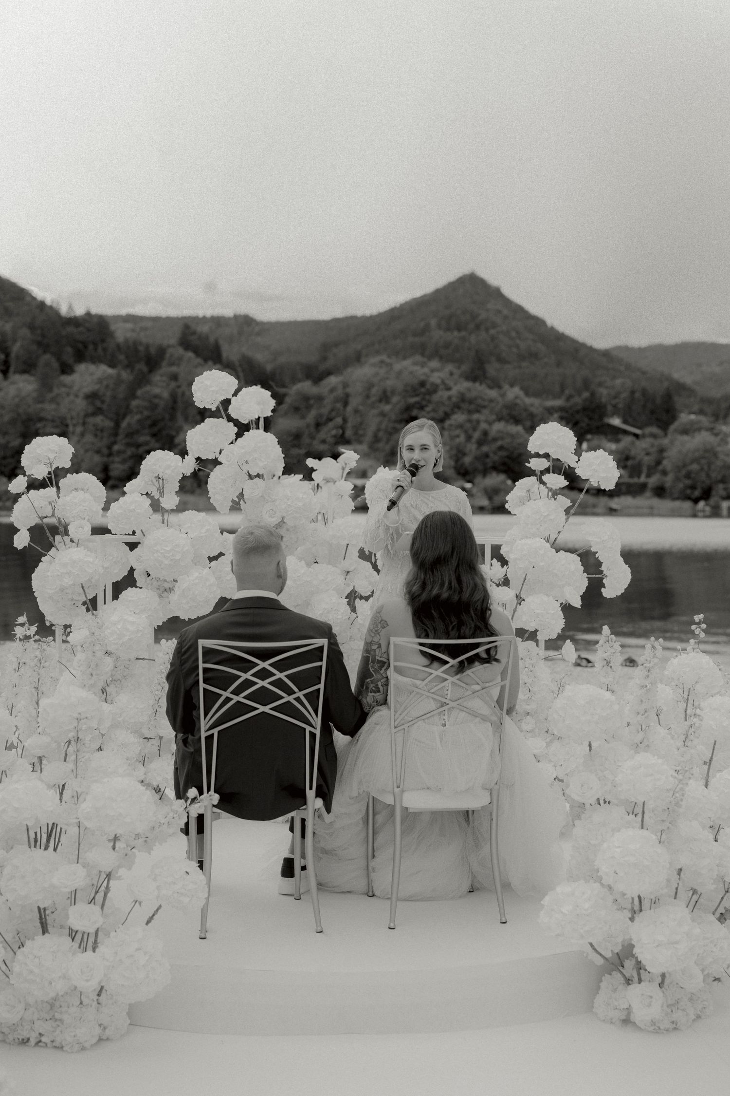 Brautpaar am Tegernsee mit weißer Blumendeko bei der freien Trauung am See