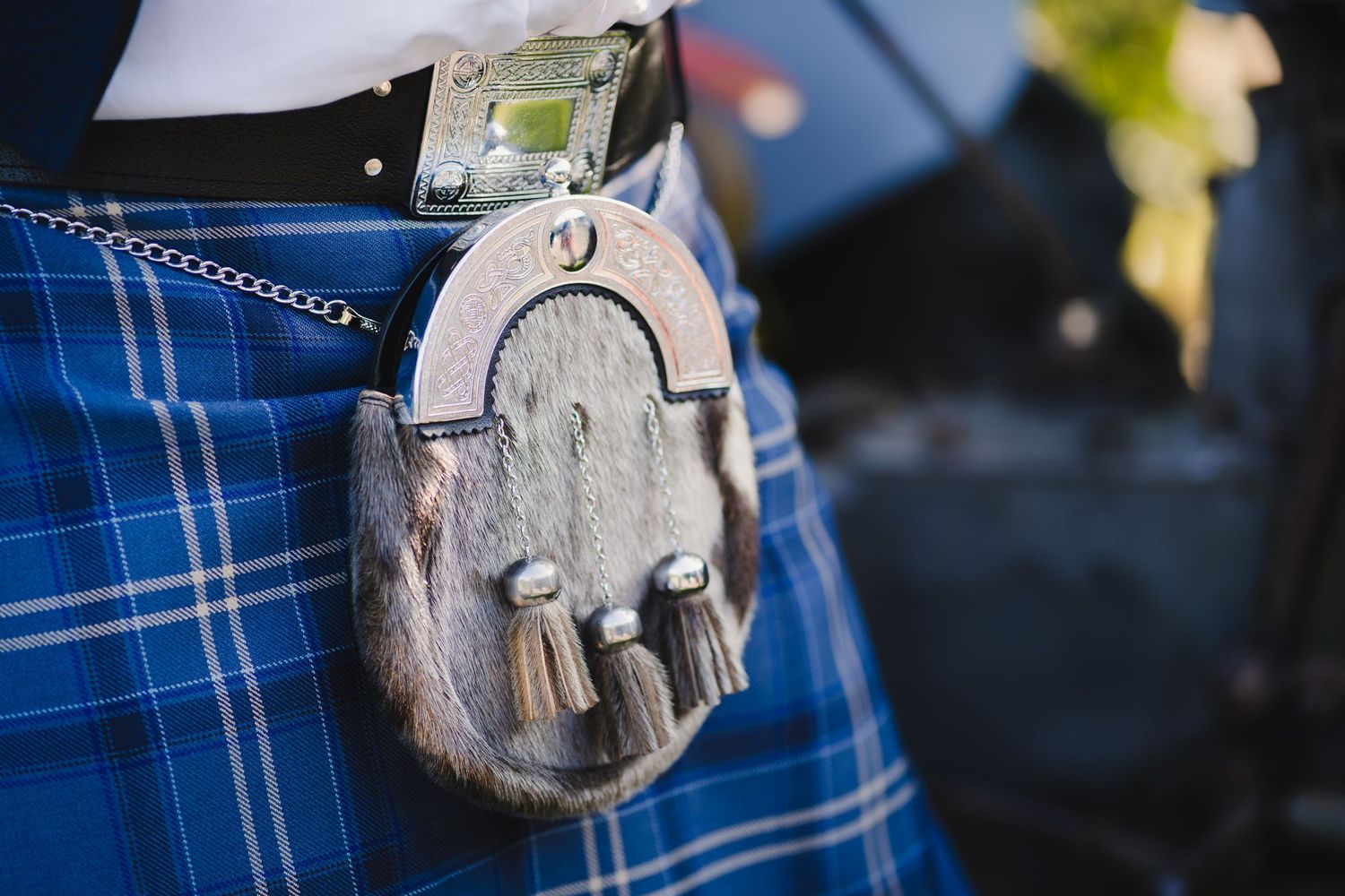Traditional Scottish sporran with silver details against blue tartan kilt.