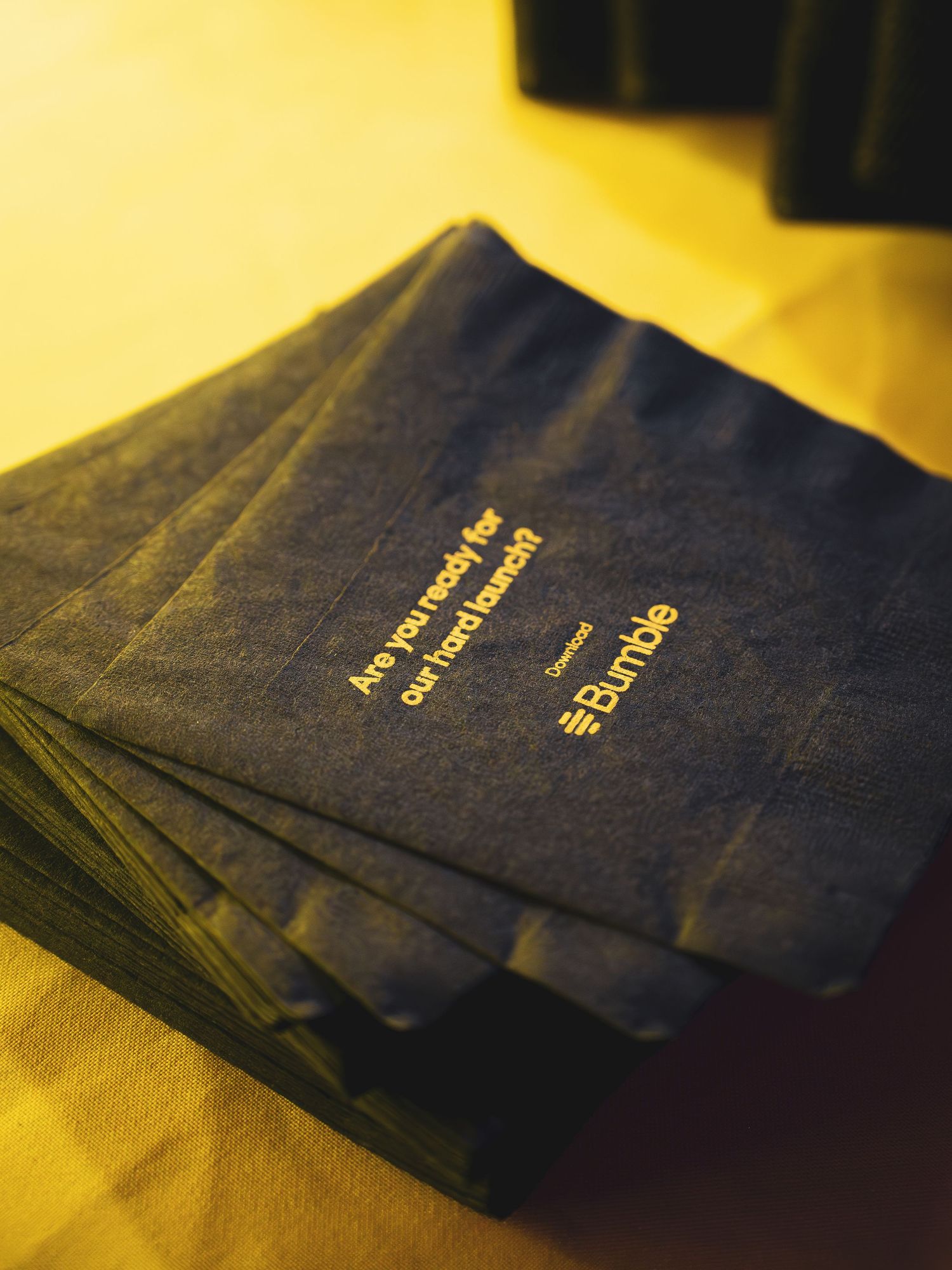Stack of navy blue passports with gold lettering on a yellow surface.
