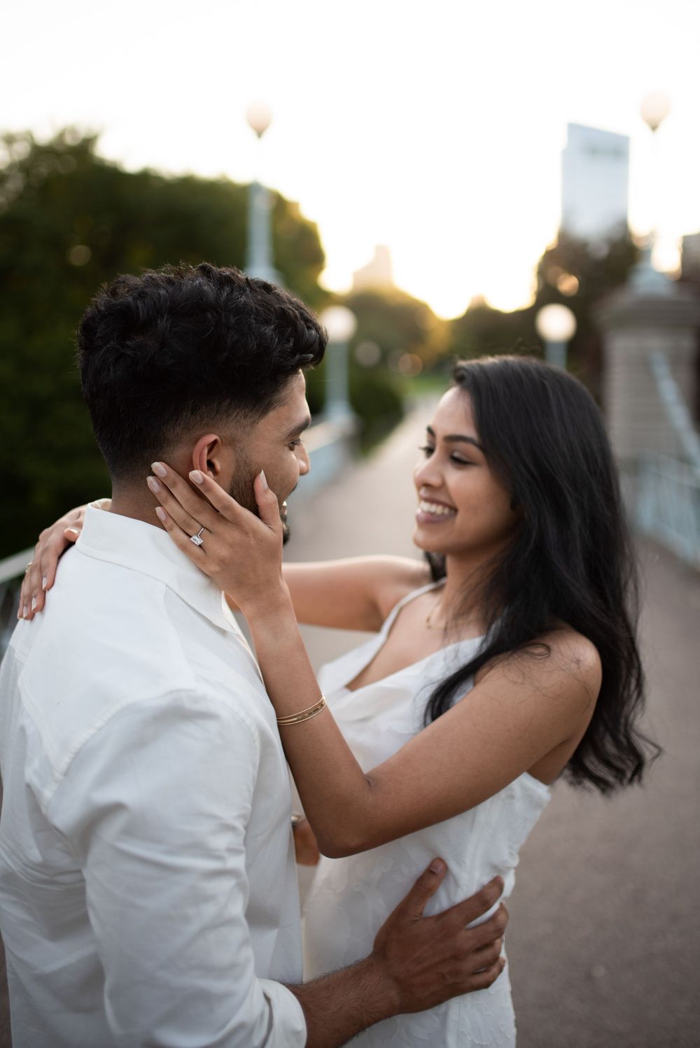 An intimate moment captured between a couple on a bridge during golden hour.
