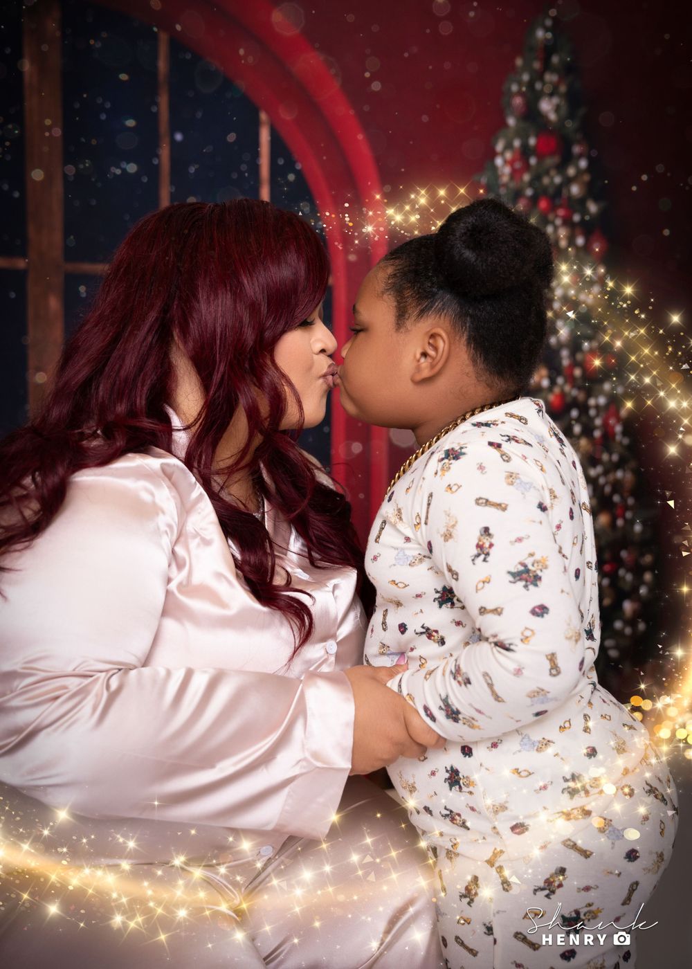 Intimate mother and child moment captured in front of Christmas tree with sparkling lights.