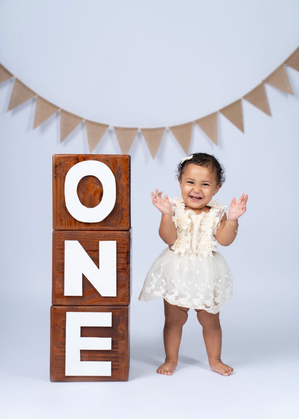 Studio setup with wooden ONE blocks and festive bunting banner.