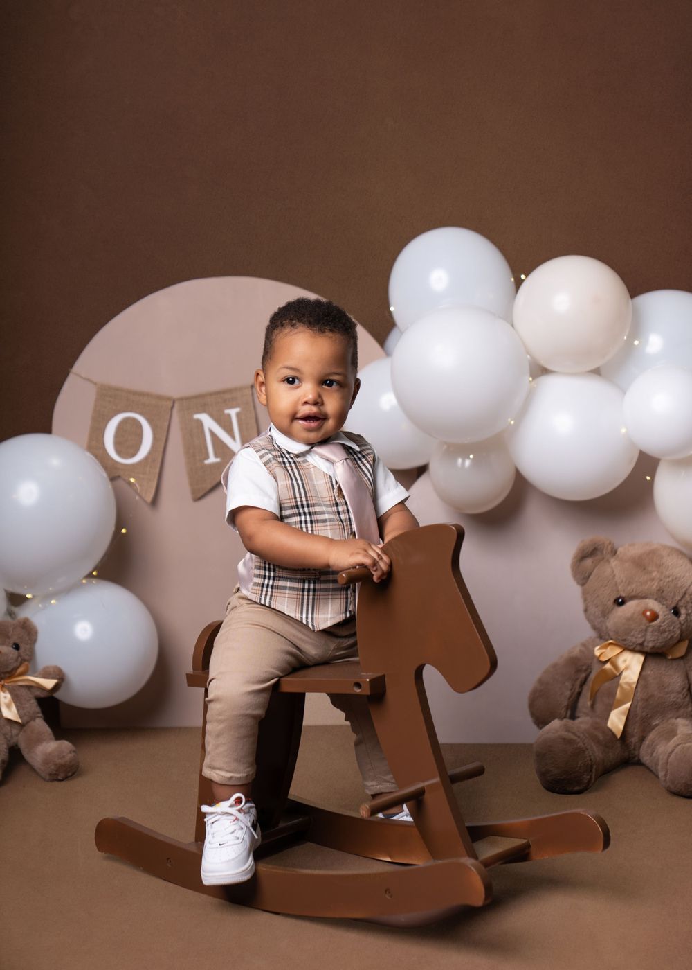 First birthday setup with balloons, ONE letters, and teddy bears.