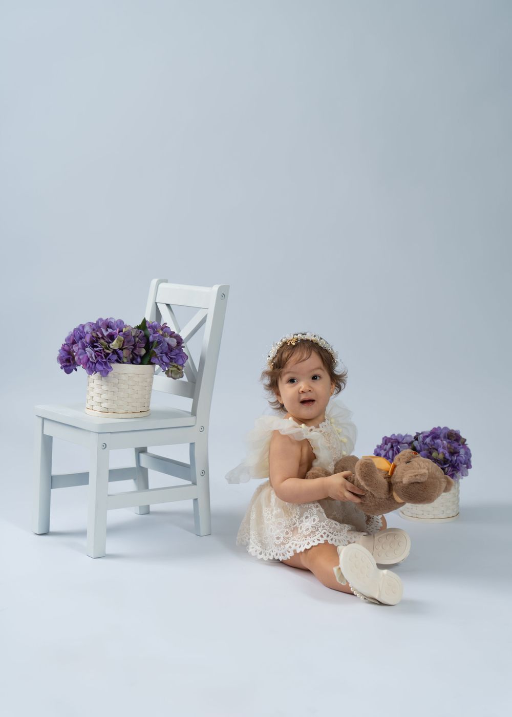 White chair with purple flowers and decorative elements against light background.