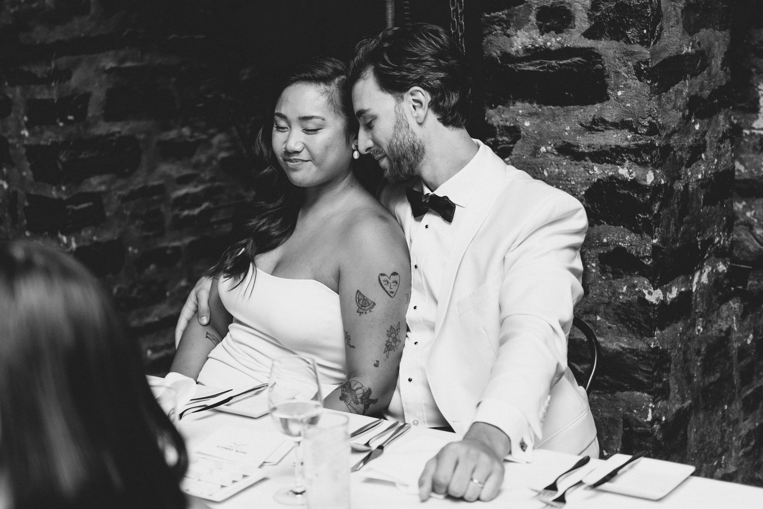 A newlywed couple shares a joyful moment at their black and white wedding reception.