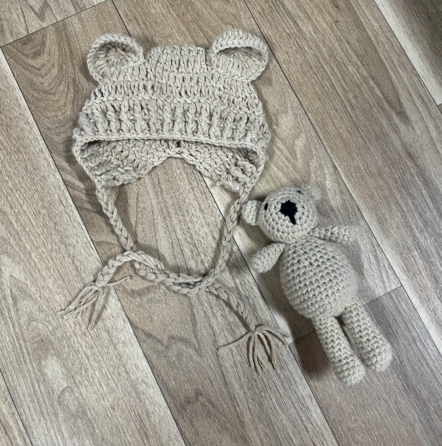 Handmade crochet elephant toys in light grey color displayed on wooden flooring.