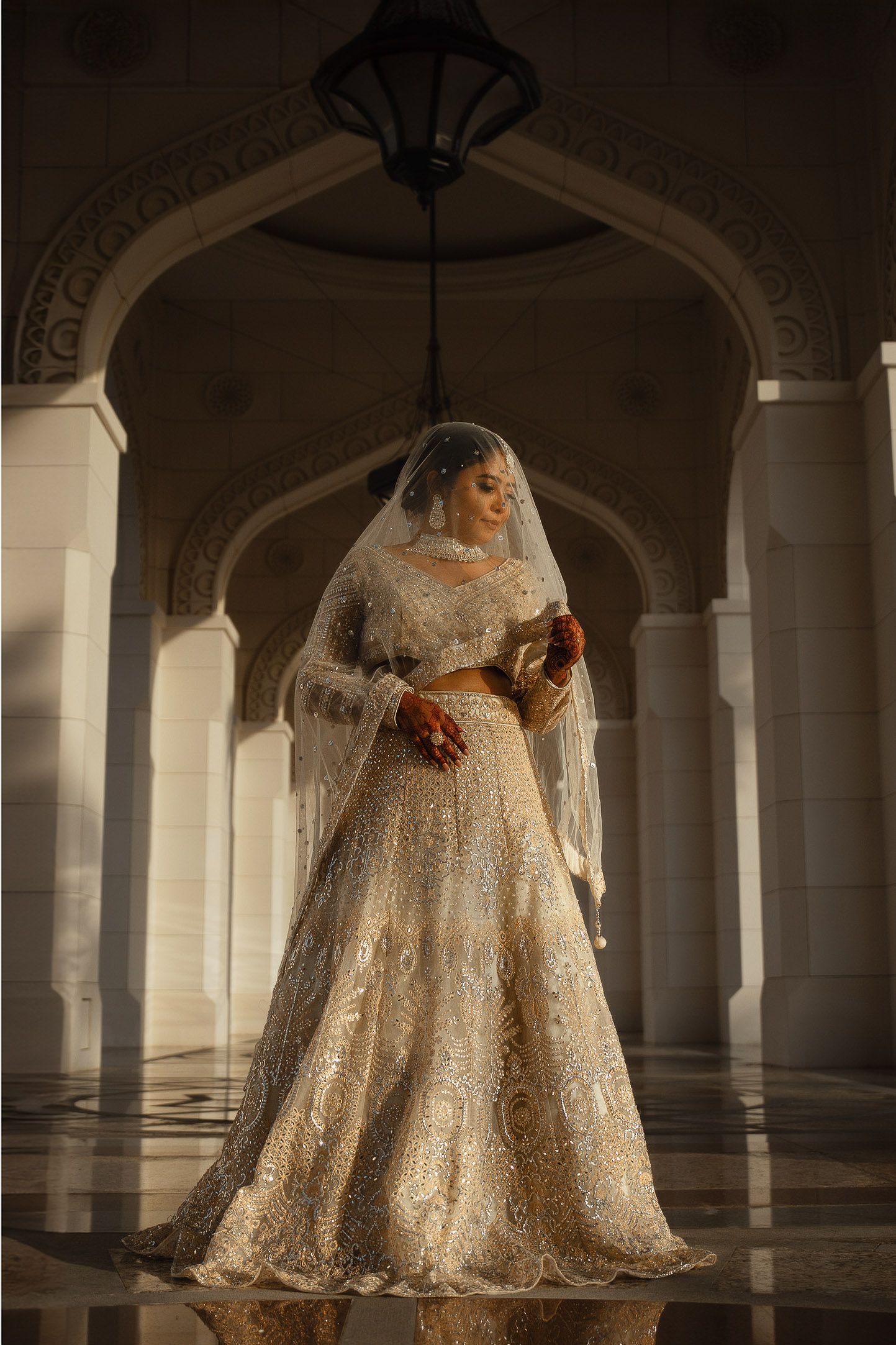 Bride portrait in grand archway with flowing wedding gown