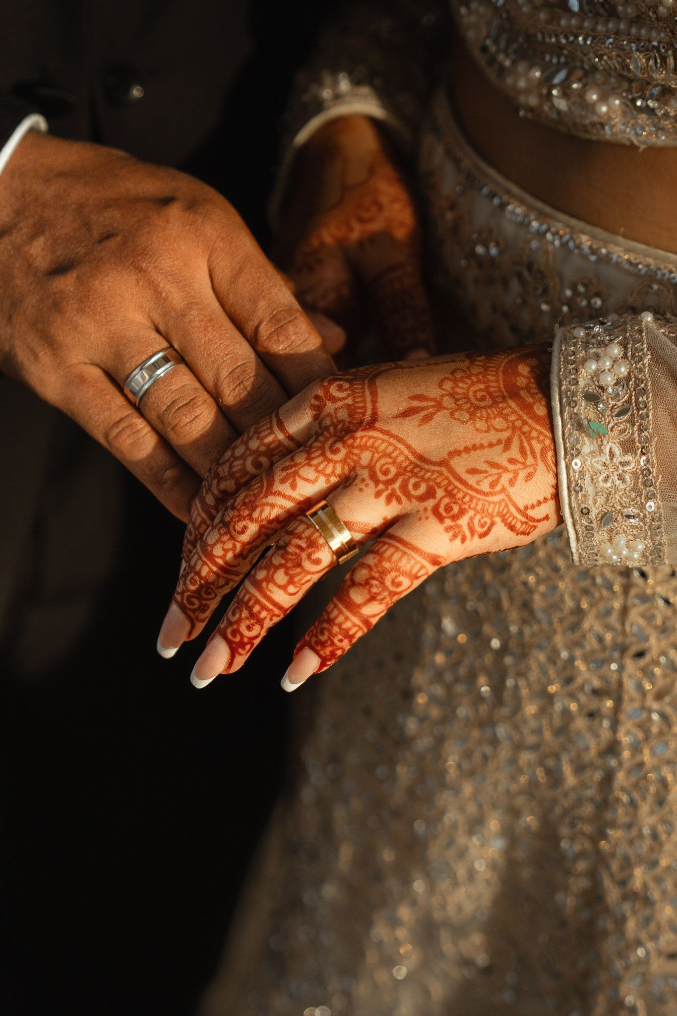 Close-up detail of bride’s hands with intricate henna design