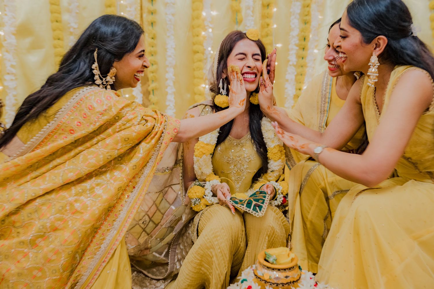 Bridesmaids applying turmeric during traditional Mehndi celebration