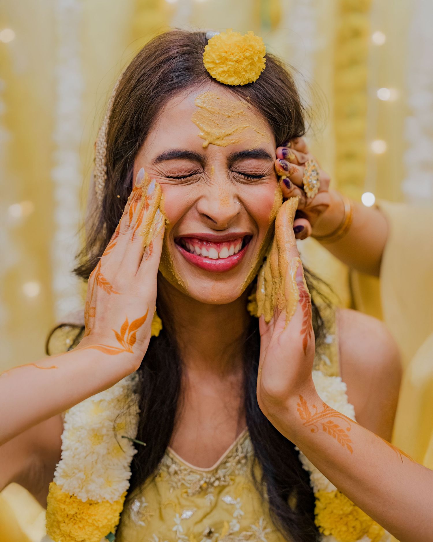 Joyful Haldi ceremony portrait of bride in vibrant yellow attire