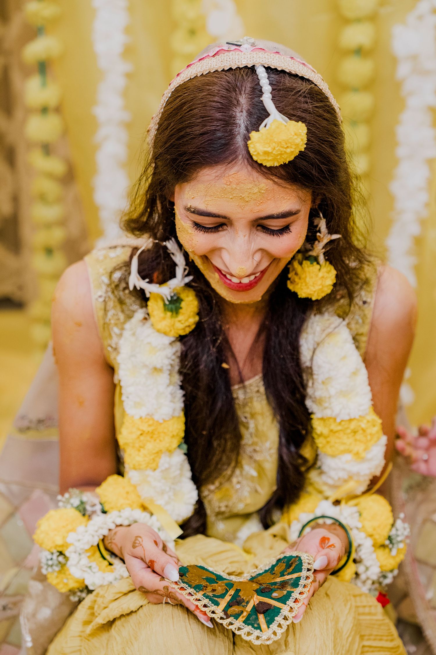 Bride during Haldi celebration with floral details