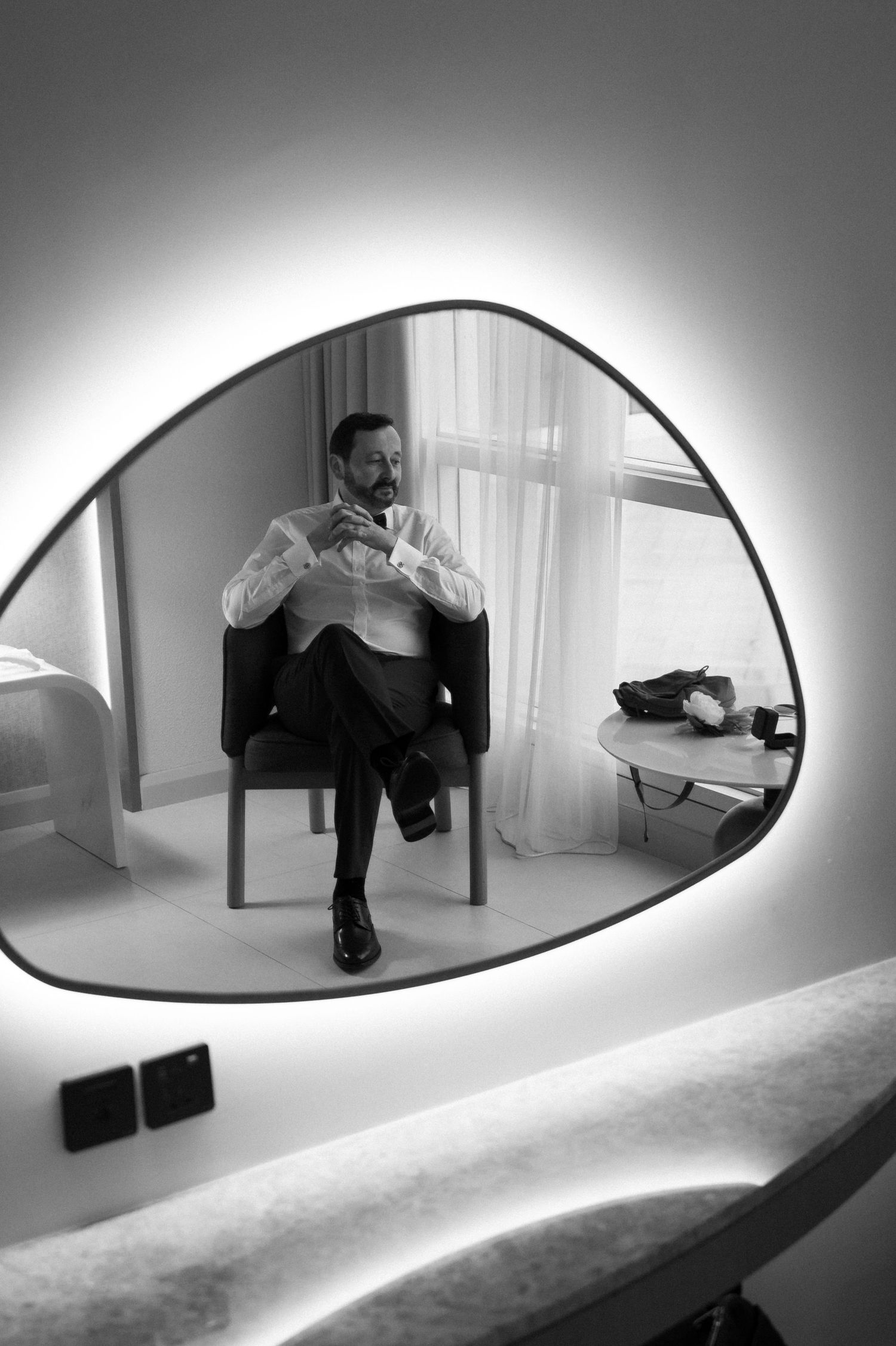 Black and white groom getting ready portrait reflected in hotel mirror