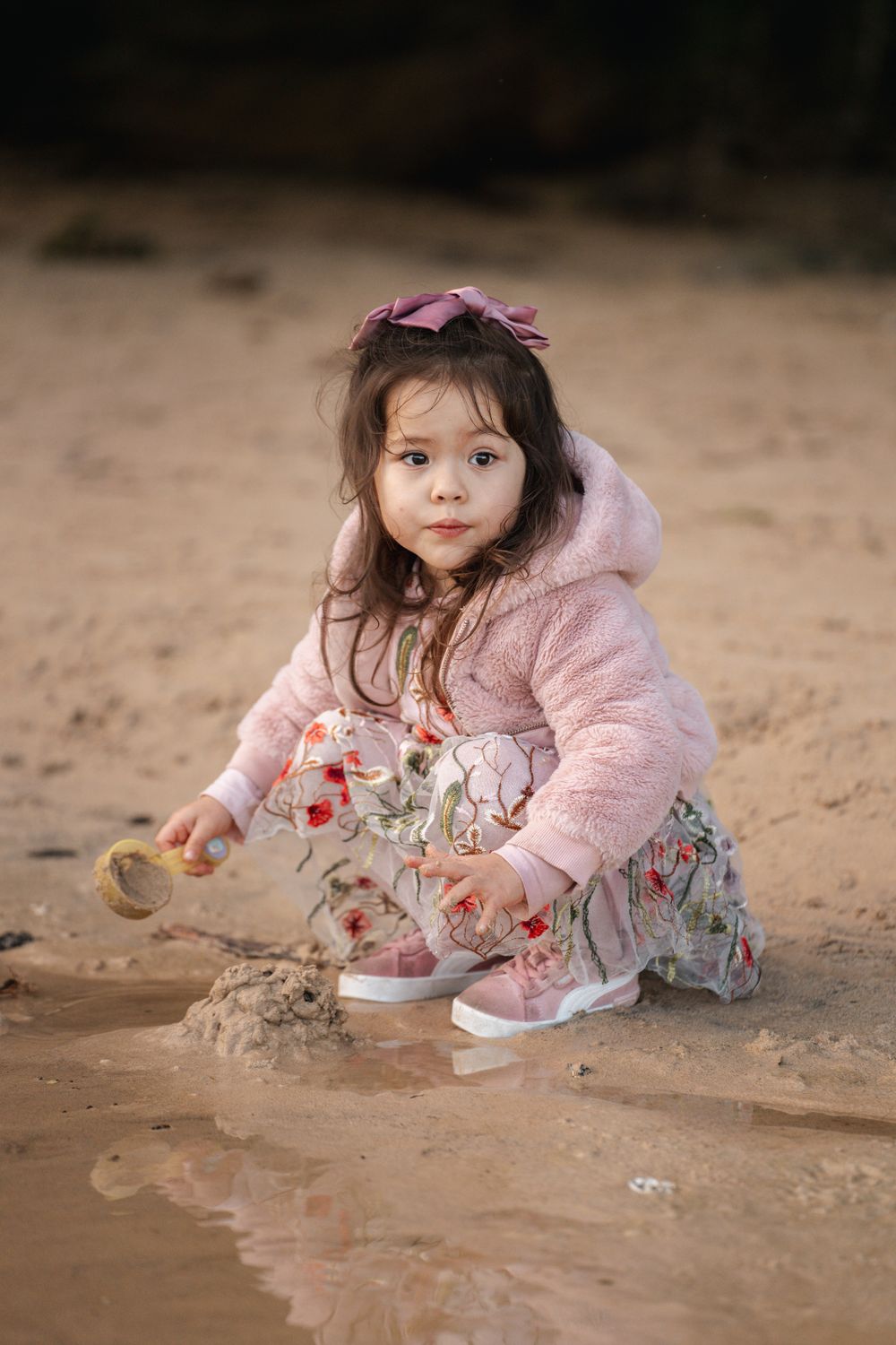 little girl playing in the sand at the end of a family photoshoot in Sydney clifton garden