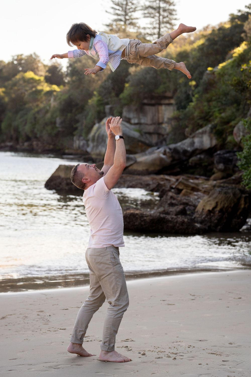 Dad throws son into the air during a family photoshoot in Manly, Sydney's northern beaches