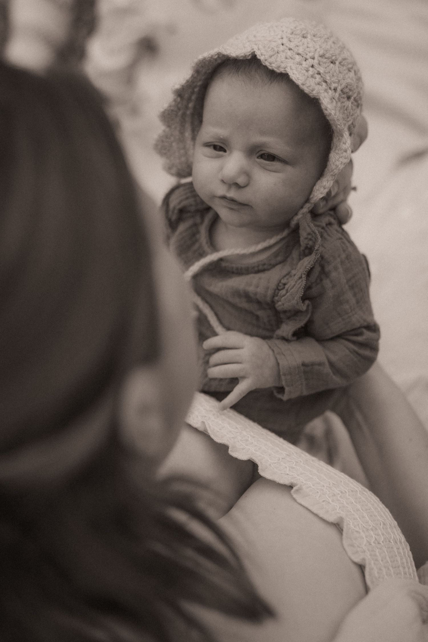 A series of sepia-toned close-up photographs showing a baby wearing a knit bonnet and warm clothing.