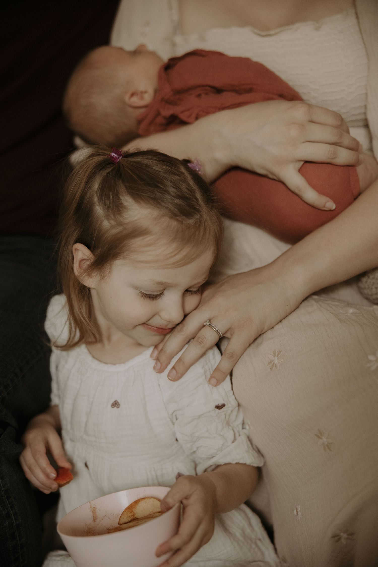 A series of intimate photos showing a young child in a white dress resting peacefully on a couch.