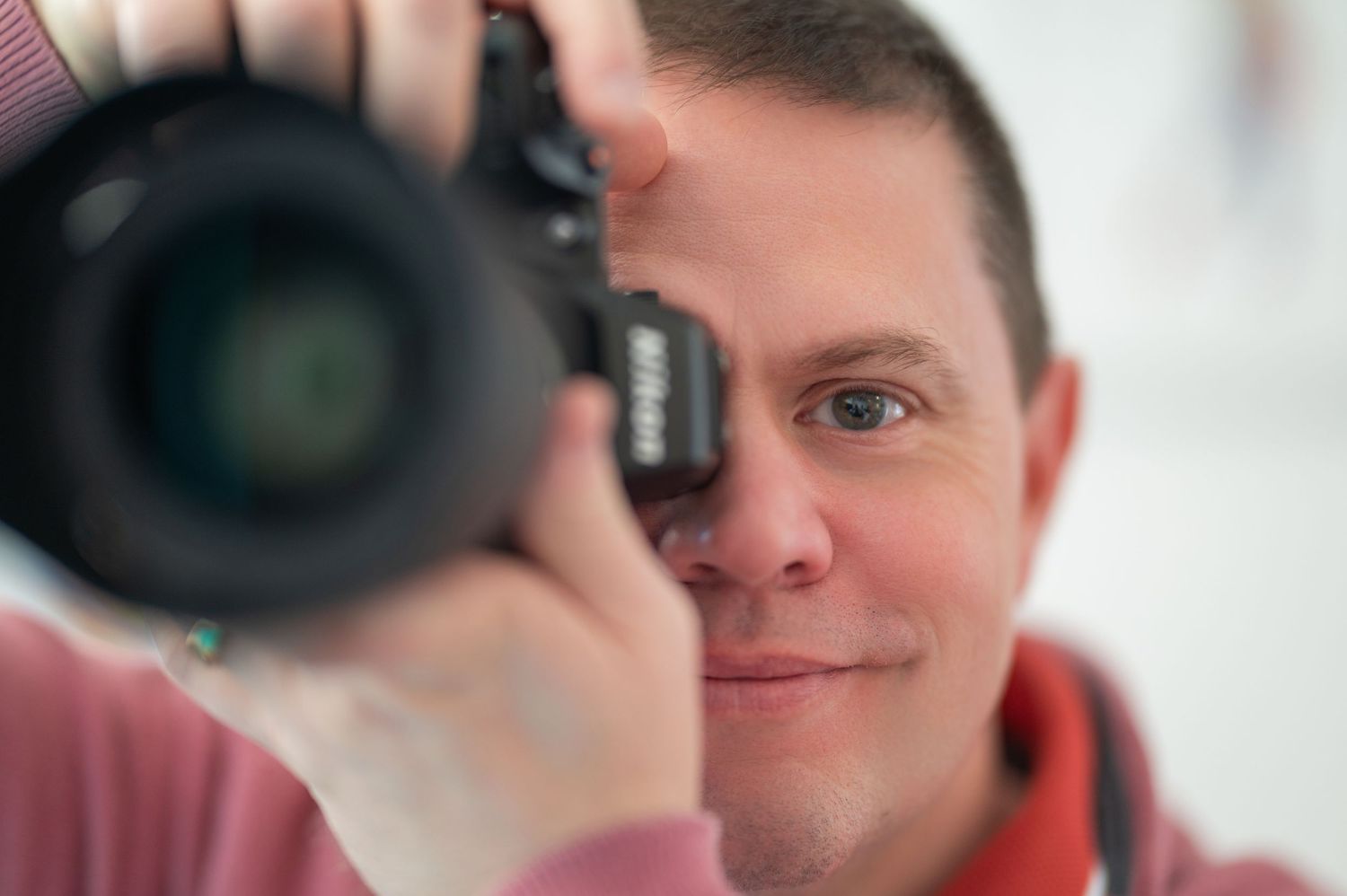 Professional photographer taking portraits with camera in bright indoor setting.