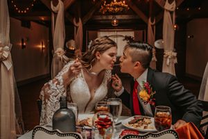 Newlywed couple sharing a fun spaghetti moment during their wedding reception in Greenville, North Carolina.