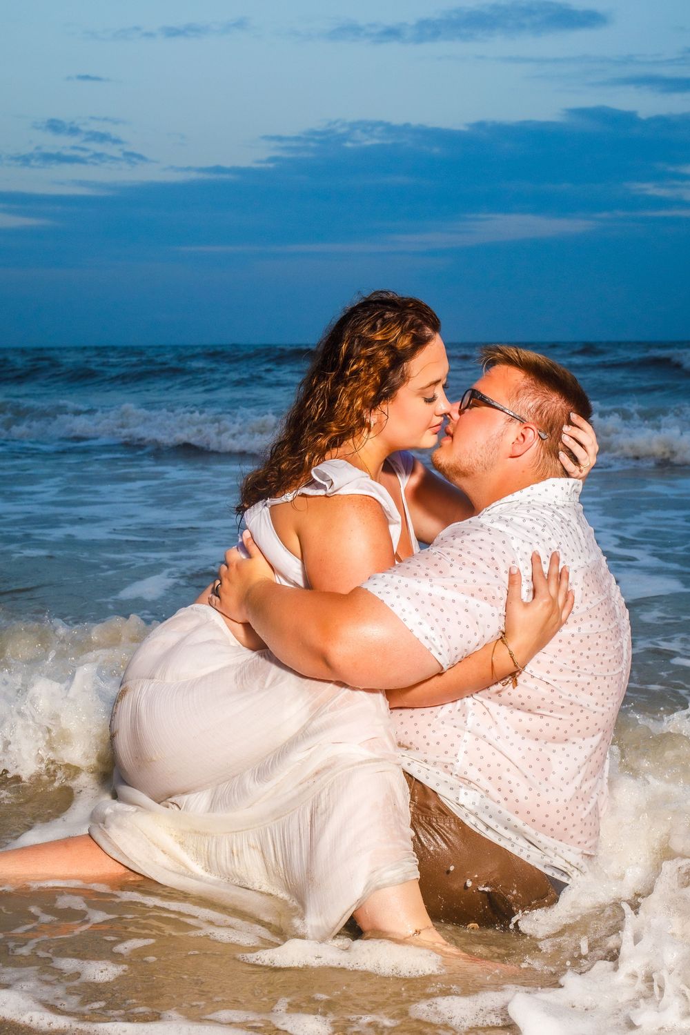 Couple passionately kissing in the ocean during a romantic beach photography session on Topsail Island, NC