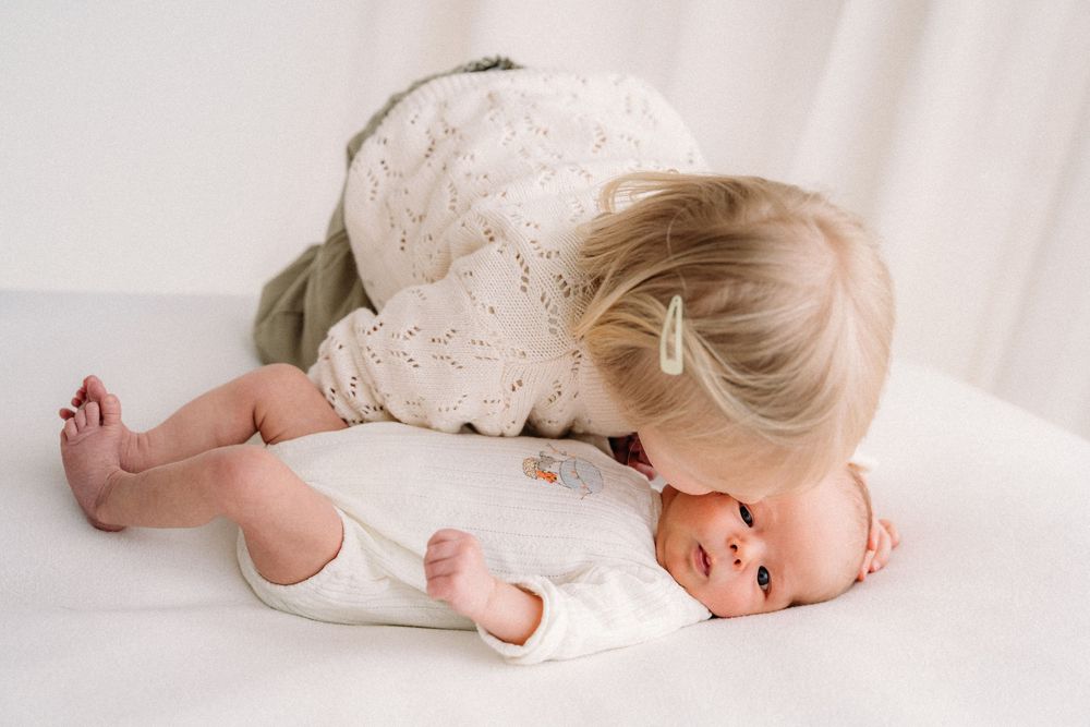 Intieme pasgeboren fotoshoot met zachte poses in lichte studio