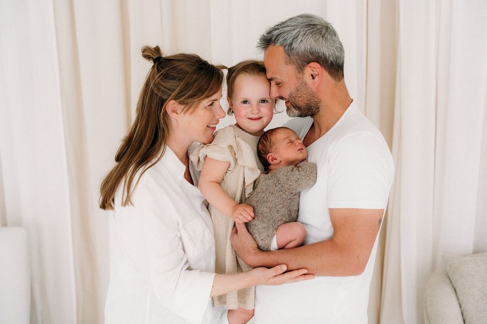 Liefdevolle gezinsfoto met newborn bij natuurlijke lichtinval